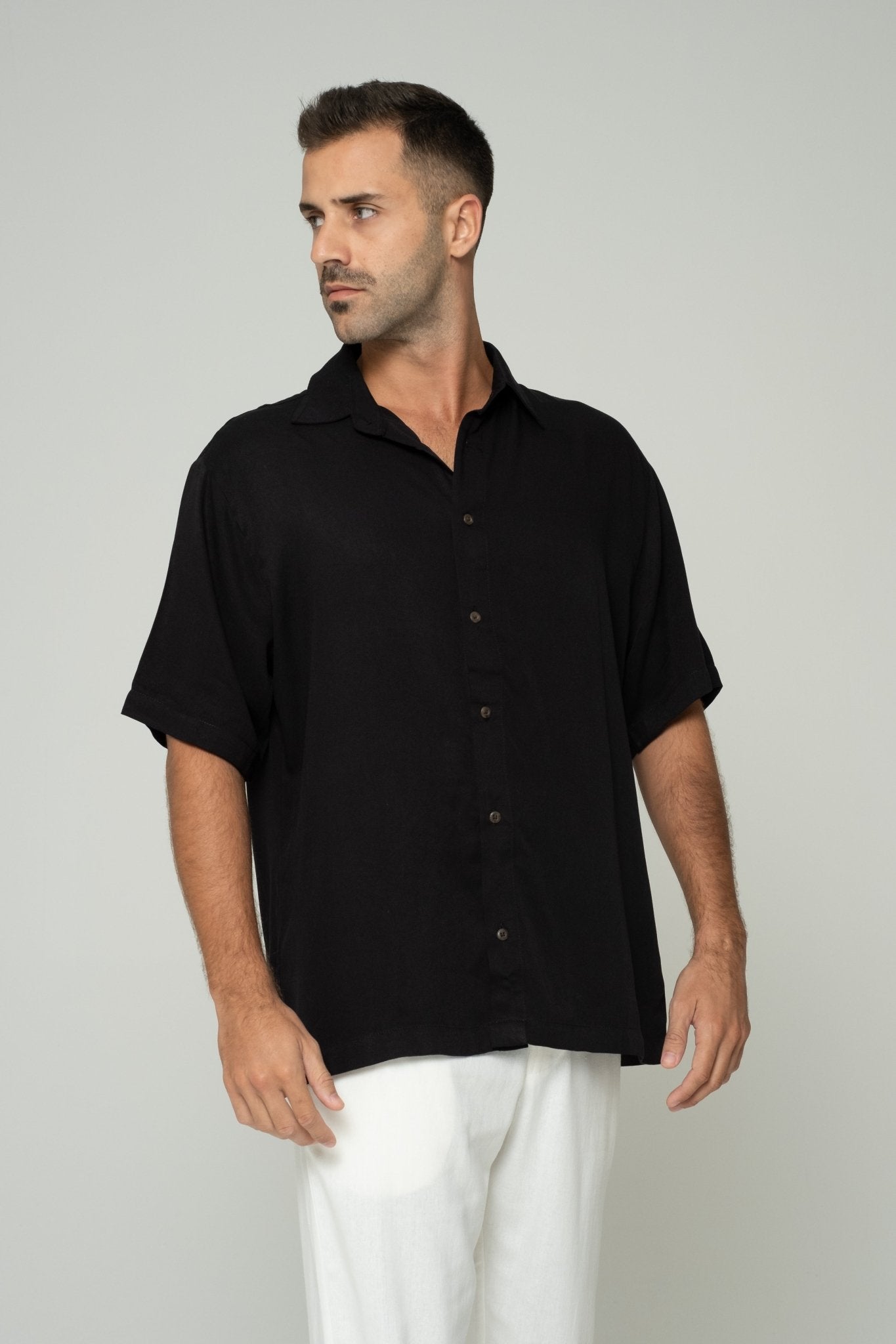 alt="Affine shirt in black cotton blend, relaxed fit with curved hem, front view."