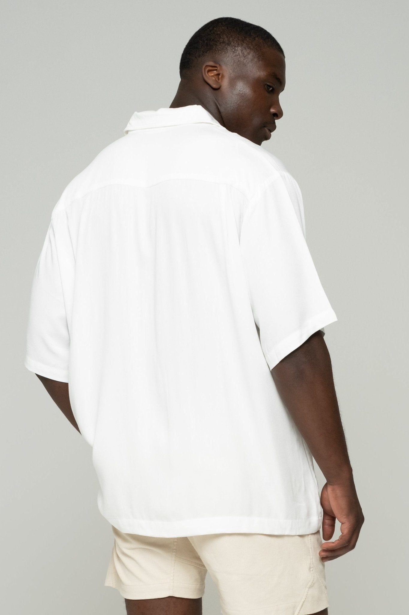 alt="Side view off-white Affine shirt, curved hem and sleeve detail."