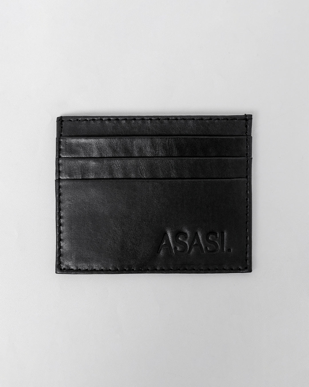 alt="Black leather card holder with stitched edges, compact minimalist design, U‑shaped pocket opening."