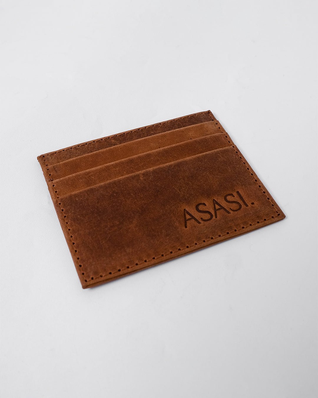alt="Front view brown leather card holder, slim carry, smooth polished grain."