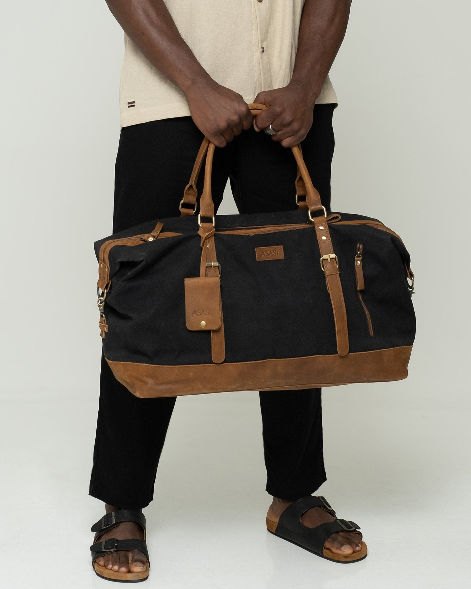 alt="Marshal duffle bag in tan leather, full-size weekender with top handles and detachable strap."