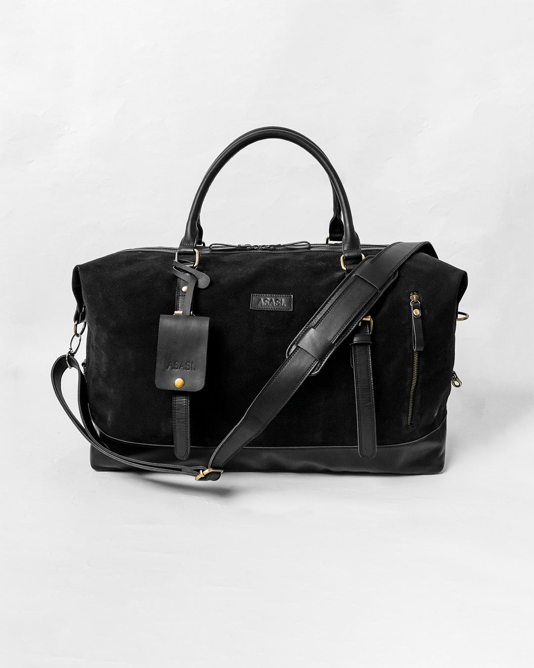 alt="Triple Black duffle bag in black leather, sleek weekender with top handles and detachable strap."