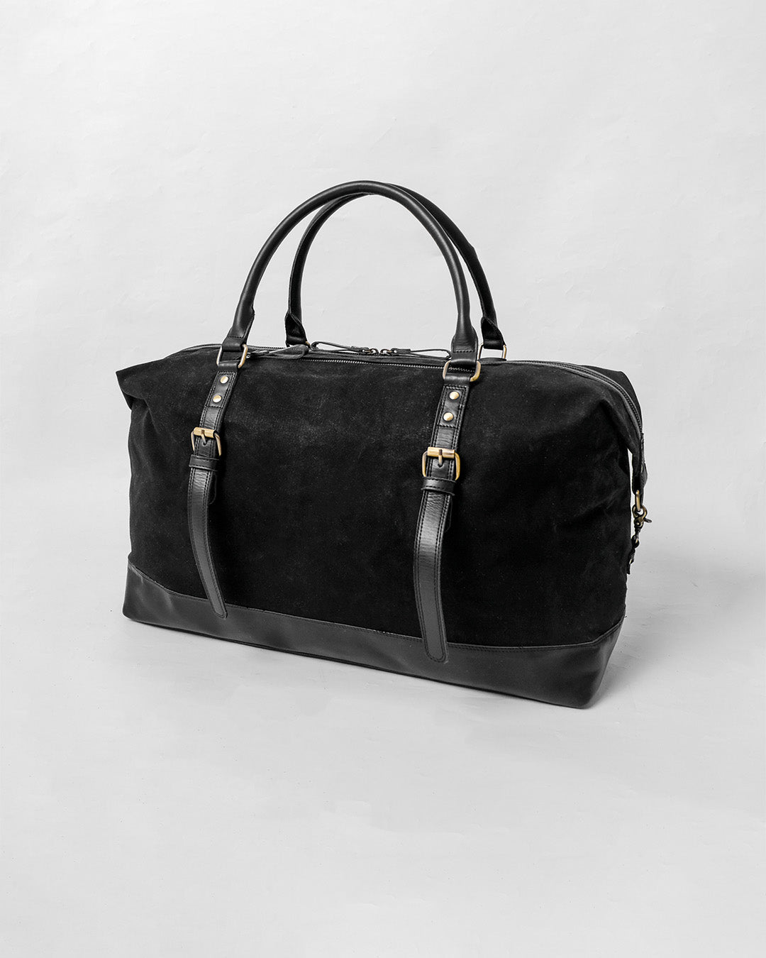 alt="Front view Triple Black leather duffle, spacious interior with zip top and polished hardware."