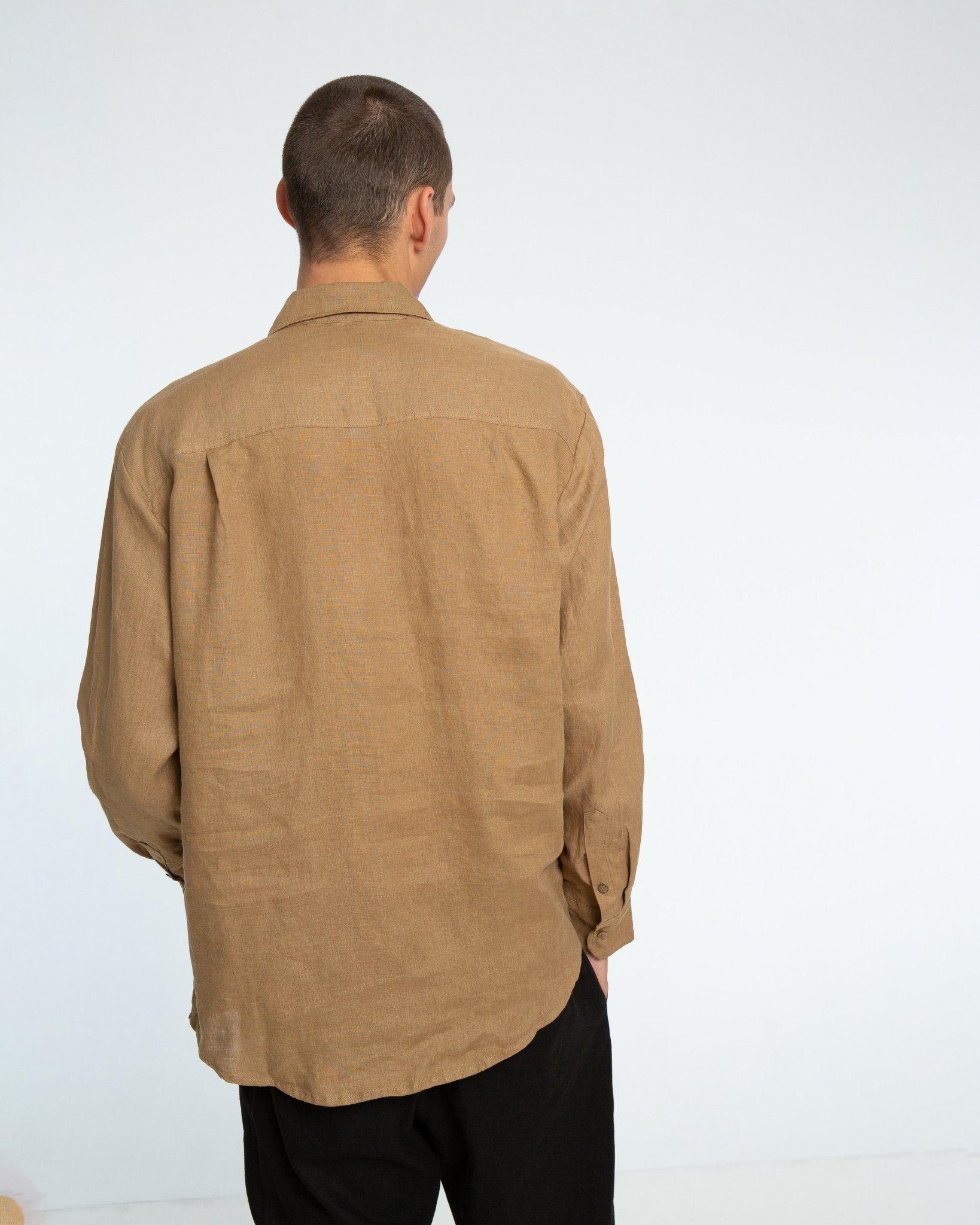alt="Detail of tobacco Flak shirt button‑down collar and pocket stitching."