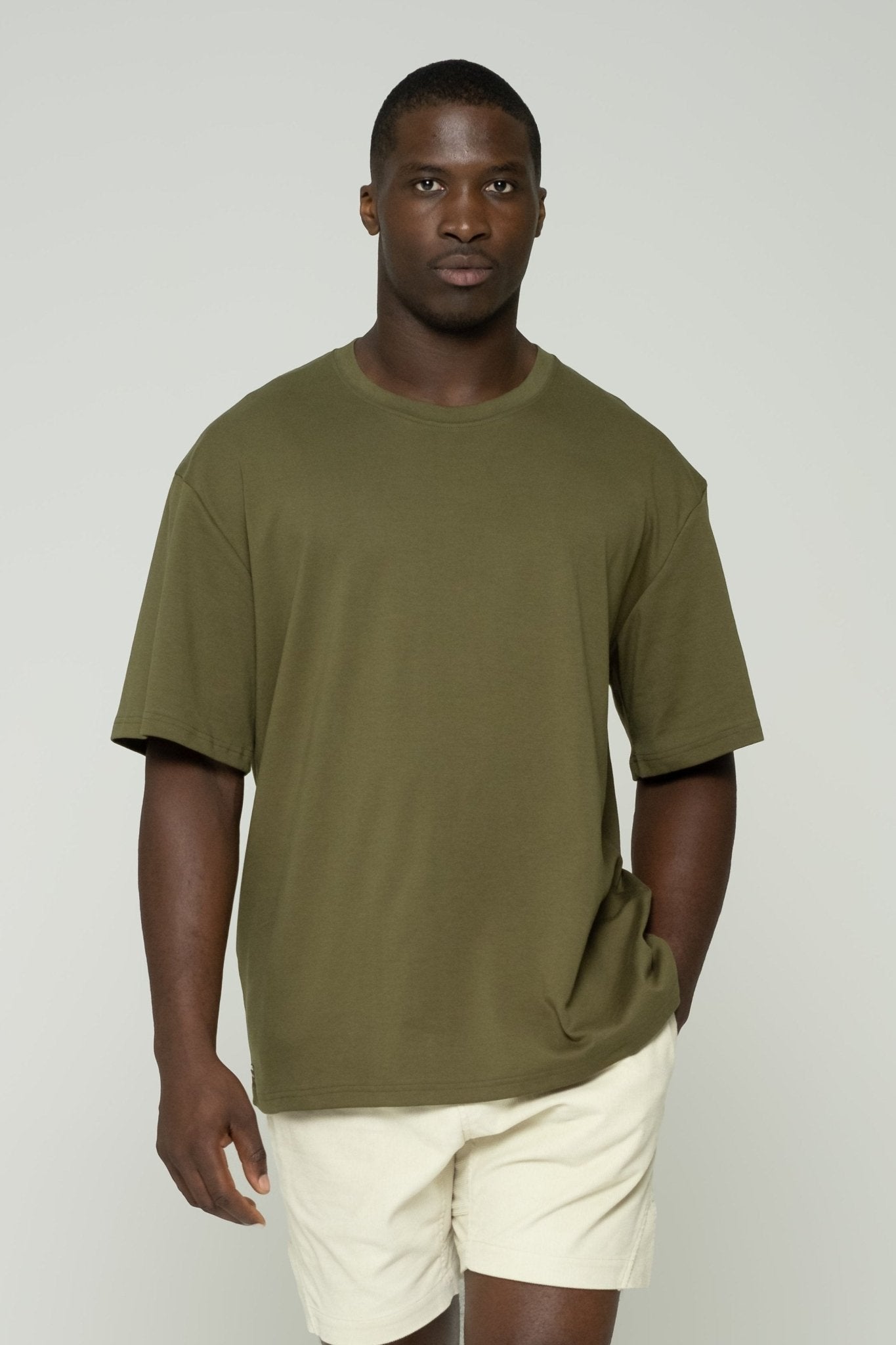 alt="Front view Kavash Vos dark green oversized t‑shirt, heavyweight cotton crew‑neck with roomy silhouette."