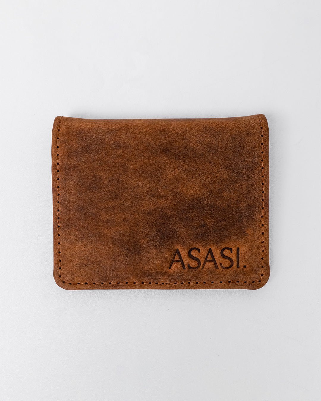 alt="Brown leather saddle clip with brass-tone metal clasp, adjustable leather strap."