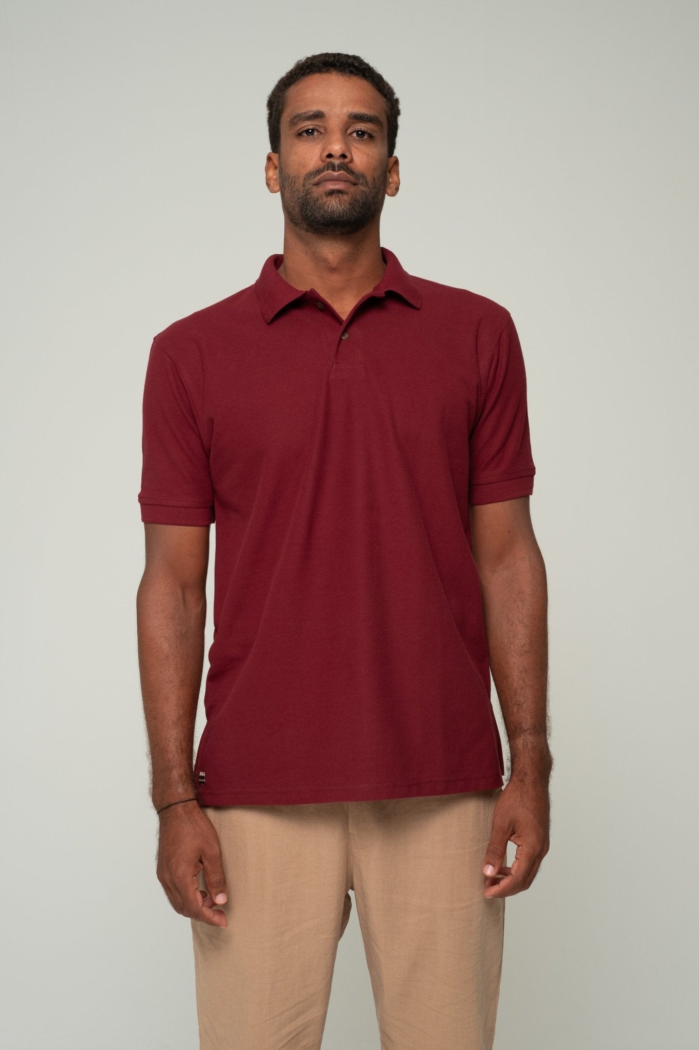 alt="Close‑up of merlot ASASI polo shirt fabric texture and collar detail, structured yet soft finish."
