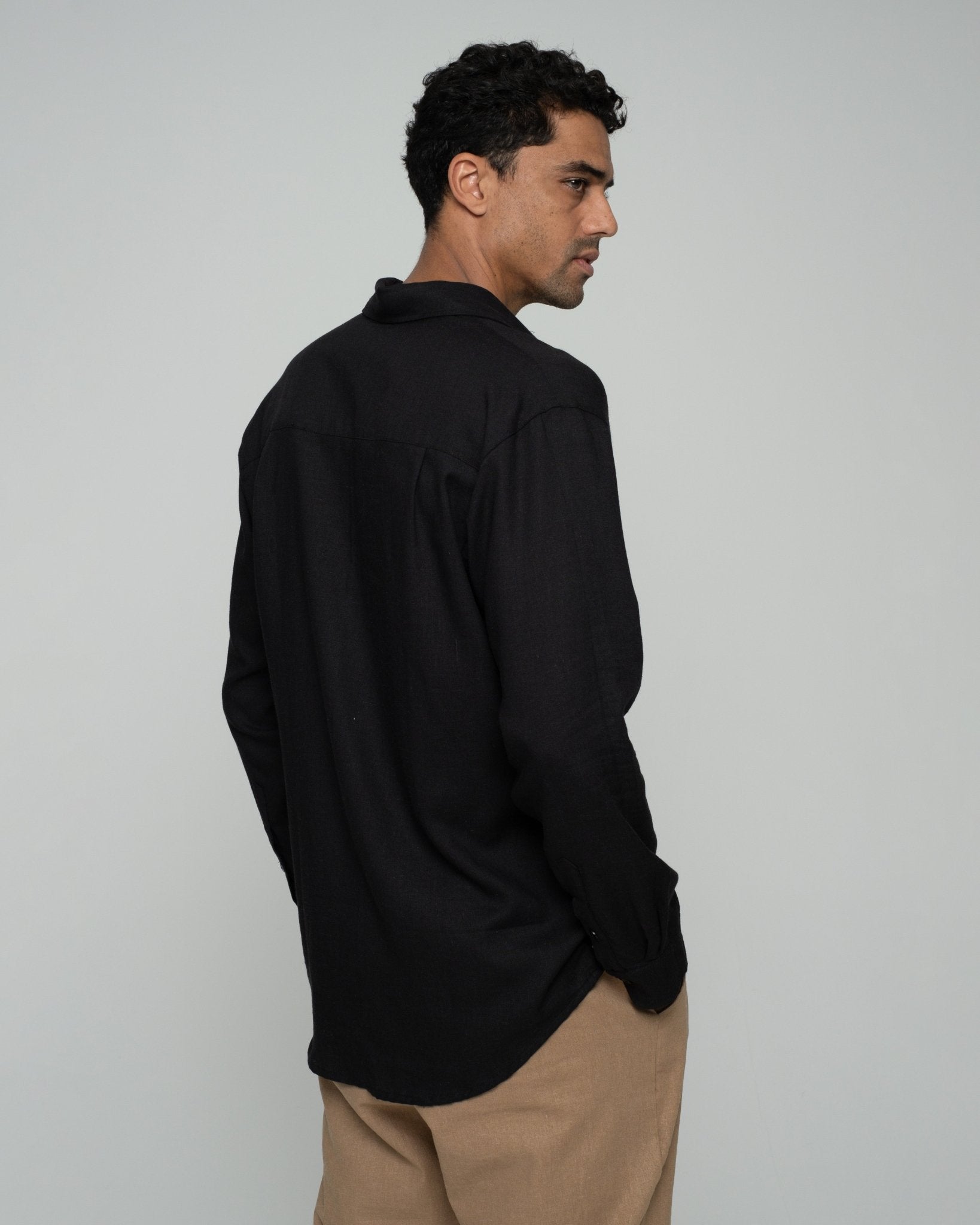 alt="Side view black Shadow long-sleeve shirt, sleeve and hem detail."