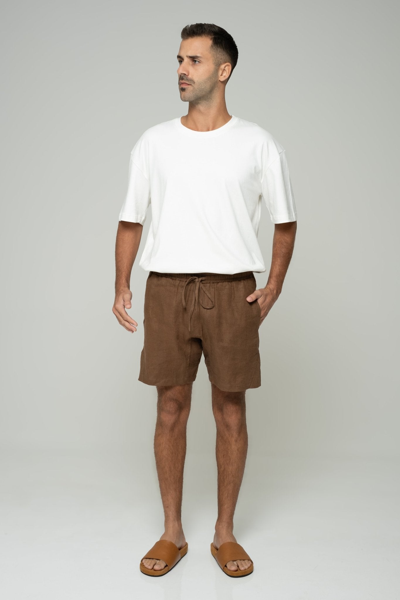 alt="Coca shorts in warm tan cotton blend, mid-length with drawstring waistband, side profile."