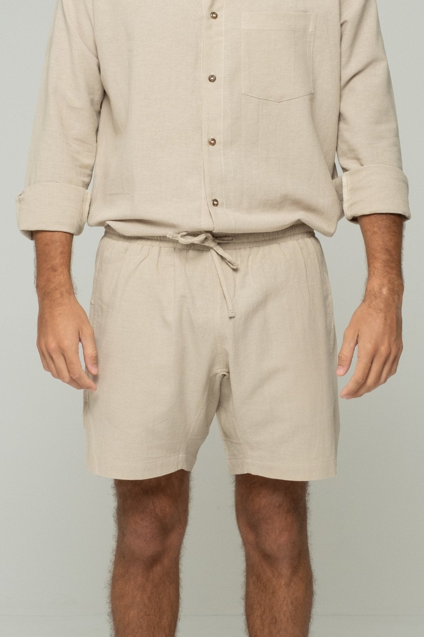 alt="Detail of drawstring and pocket stitching on beige Hearthstone shorts."