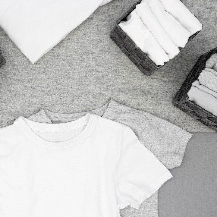 Gray t-shirt with white undershirt on a gray surface