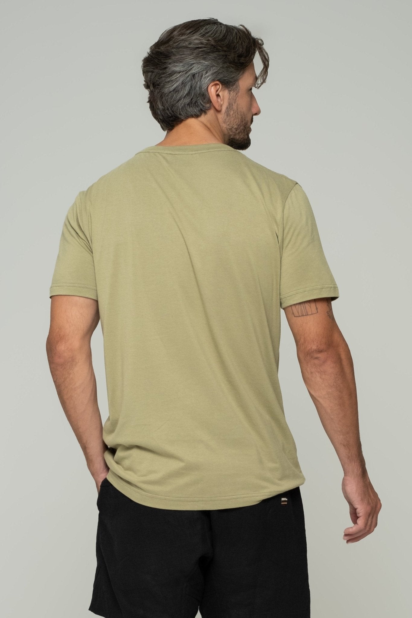alt="Front view olive Vāyu t‑shirt, curved hem and regular fit silhouette."