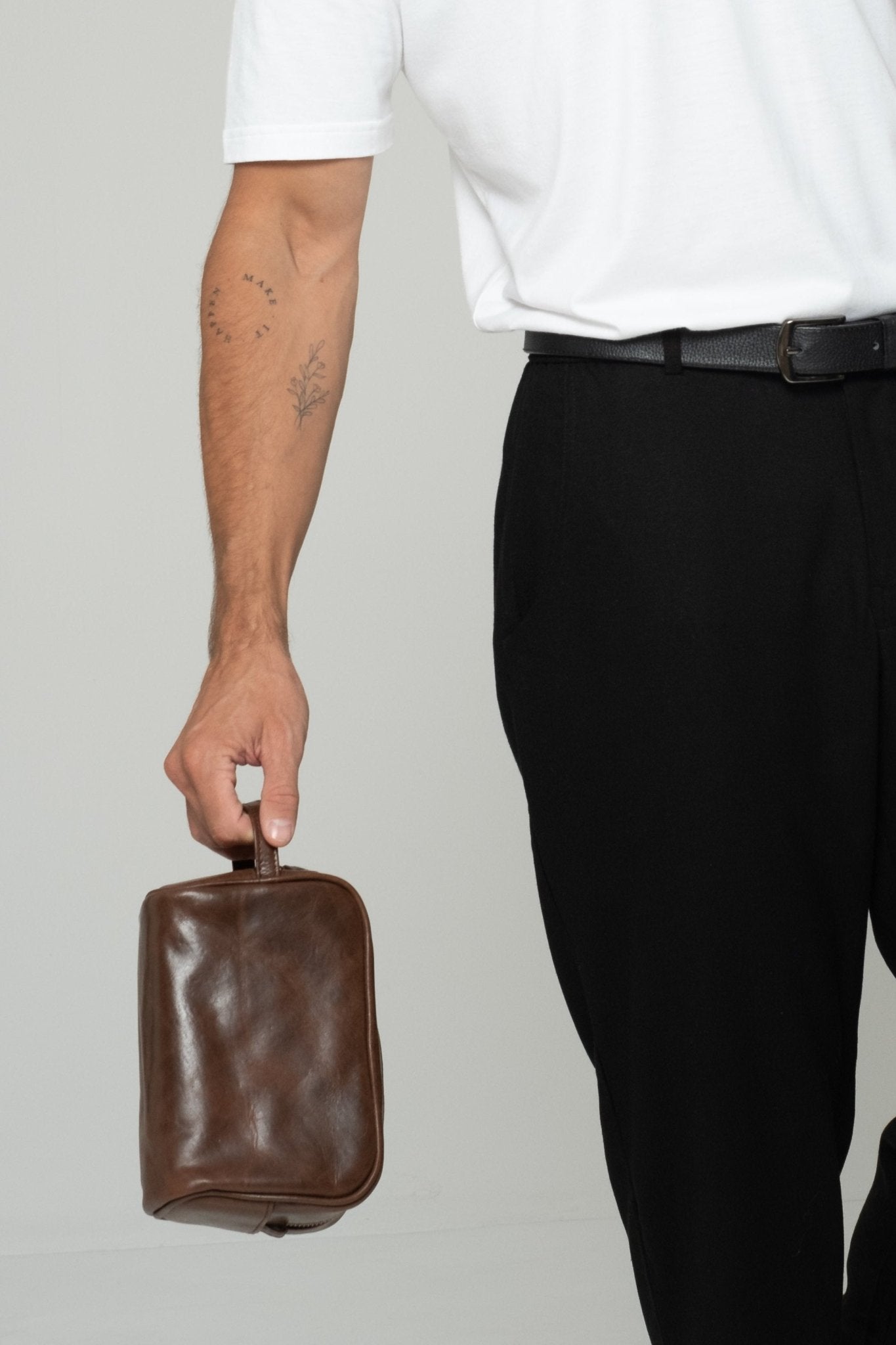 alt="Saddle leather wash bag, compact toiletry kit, top zipper and structured silhouette."